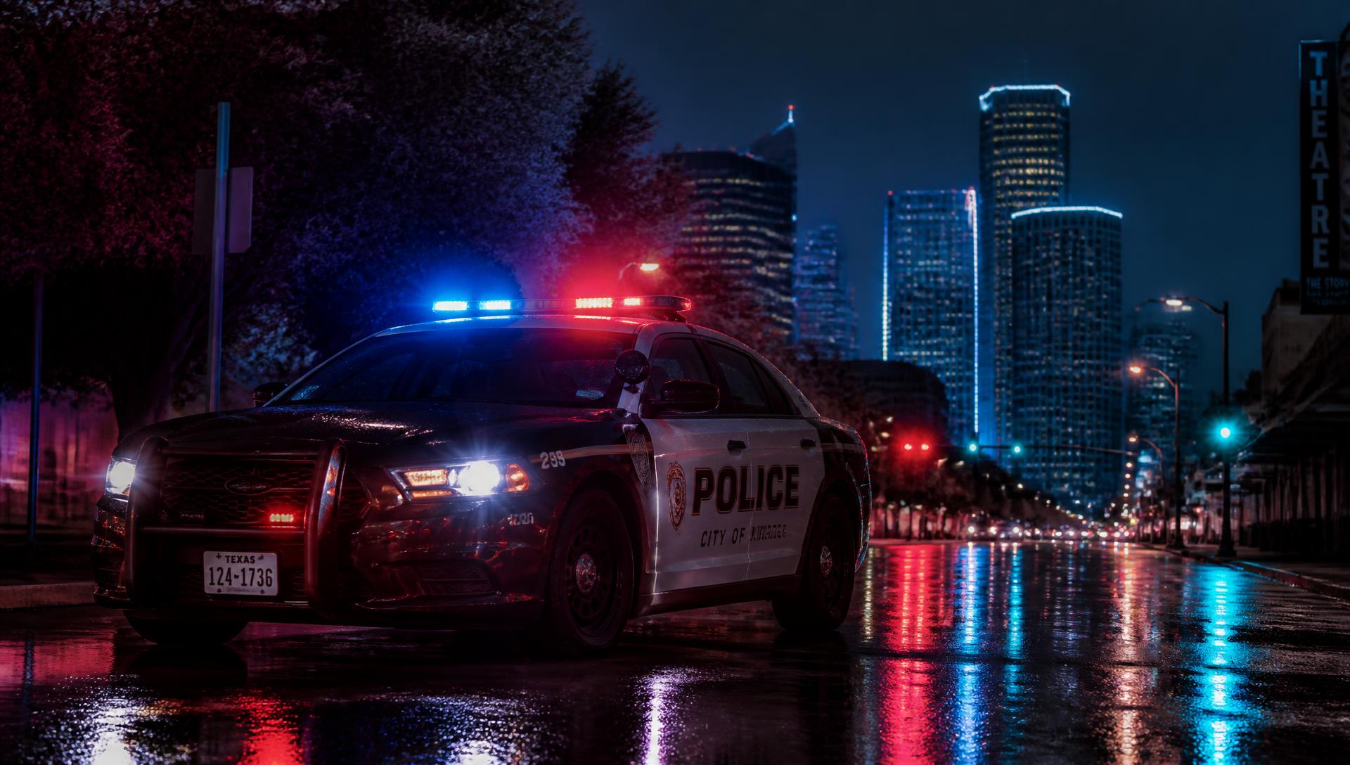 Police patrol car at night with city lights